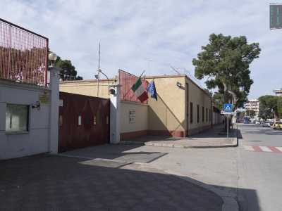 Siamo di fronte all�entrata caratterizzata da un cancello rosso scorrevole sul quale � stato raffigurato lo stemma con il pino verde della Brigata Pinerolo